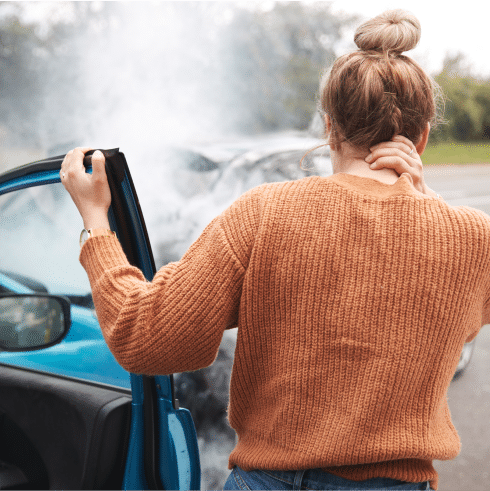 Woman rubs her neck in pain after a car crash.